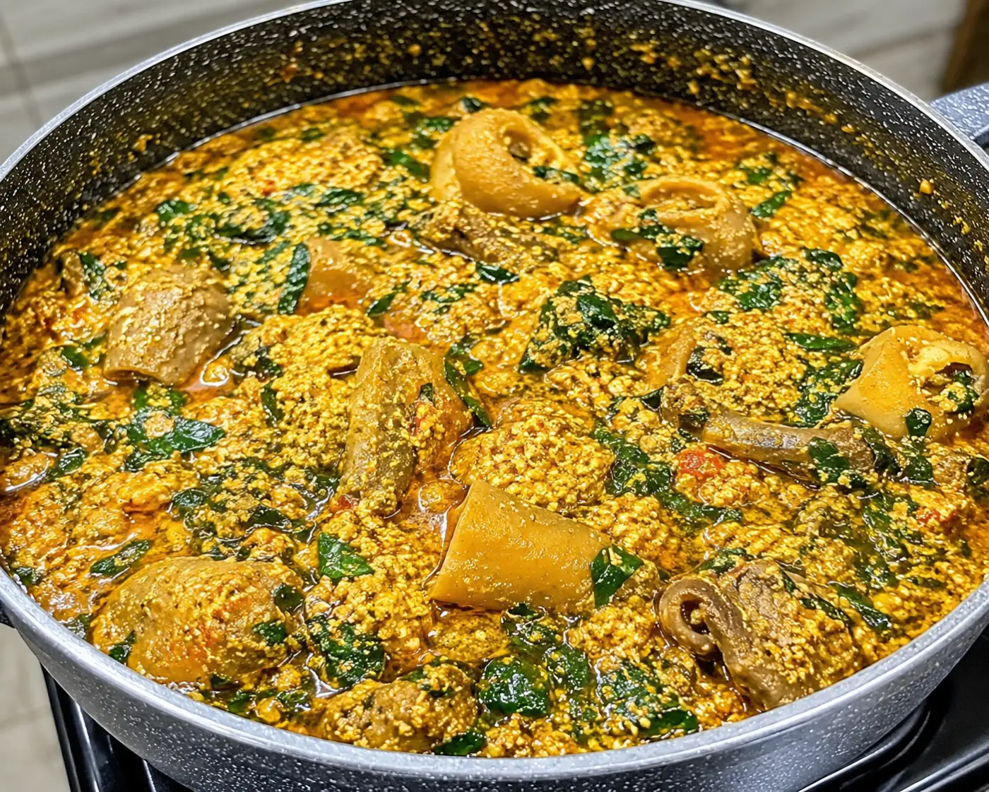 Egusi soup simmering in a clay pot